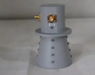 What are the key advantages of using a four-ridged horn antenna over a conventional single-ridged horn antenna?